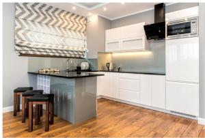 een keuken met witte kasten en een zwart aanrechtblad bij Apartament 75,143 Porta Mare in Dziwnówek