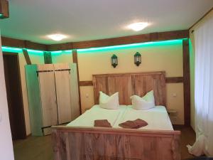 1 dormitorio con 1 cama de madera y 2 toallas en Pension zum Holzpantoffelmacher en Burg (Spreewald)