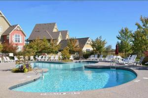 a swimming pool in a resort with white chairs at Great Location, Pool, Blue Mountain 2 BDRM Dream in Blue Mountains