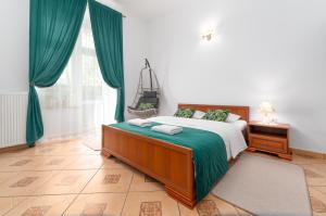 sypialnia z łóżkiem z zieloną pościelą i oknem w obiekcie Nasze Kamienice Apartament Muzyczny z antresolą w mieście Rzeszów