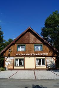 ein Gebäude mit einem Schild an der Seite in der Unterkunft Pension zum Holzpantoffelmacher in Burg