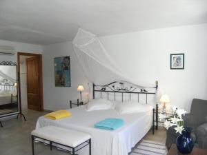 a bedroom with a white bed and a chair at Hotel Rural Can Maries in Puerto de San Miguel