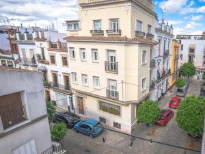 an apartment building with cars parked in front of it at Guesthouse Apartment Seville La Flamenka in Seville