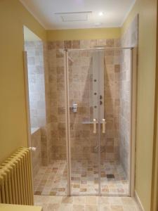 a shower with a glass door in a bathroom at La Maison d'Adelaïde in Saint-Flour