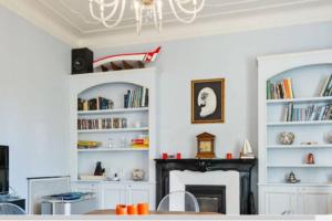 a living room with a fireplace and a chandelier at Villa Vale in Sanremo