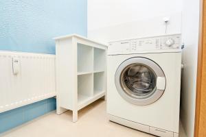 a washing machine in a white laundry room at Apartamenty Turystyczna Małgorzata in Międzyzdroje
