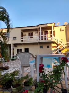 a patio with a table and a chair and a building at Pousada da Barra in Barra de São João