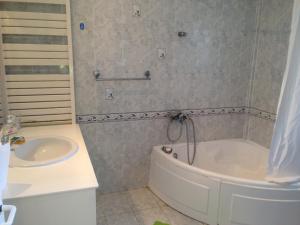 a bathroom with a tub and a sink at House with Garden in Nea Peramos +12 photos