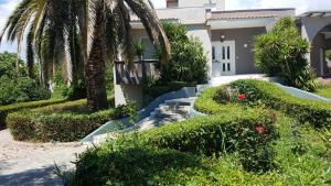 a house with palm trees and stairs in front of it at House with Garden in Nea Peramos