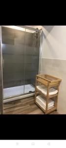 um chuveiro com uma porta de vidro e uma prateleira com toalhas em Appartamento il Torchio em Lecco