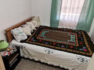 a bedroom with a bed with a blanket on it at "Pivnica i smestaj Jovanovic"- Rogljevacke pivnice in Rogljevo