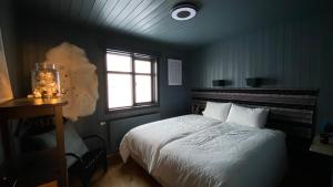 1 dormitorio con cama blanca y ventana en Marbakki Luxury Ocean Retreat, en Budhir