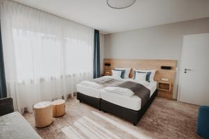 a bedroom with a large bed and a large window at Hotel Restaurant zur Marienburg in Pünderich