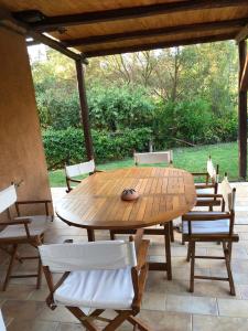 una mesa de madera y sillas en un patio en Il Belvedere - Cannelle beach Argentario - Tuscany, en Monte Argentario