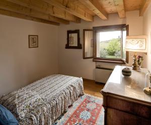 a bedroom with a bed and a table and a window at B&B Il Pettirosso in Negrar
