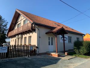 a small white house with a wooden fence at Május 1 Vendégház- Sé in Sé