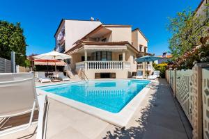 eine Villa mit einem Swimmingpool vor einem Haus in der Unterkunft Villa Allegria in Rovinj