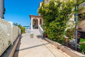 einen Gehweg vor einem Haus mit einem weißen Zaun in der Unterkunft Villa Allegria in Rovinj