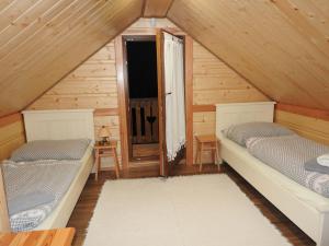 a attic room with two beds and a window at Chatka Zornica in Ždiar
