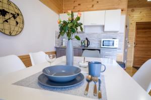 a table with a bowl and a vase of flowers on it at Pokoje Amelia in Zator