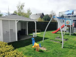 un patio con parque infantil con tobogán en Solar Bed & Breakfast, en Karwia