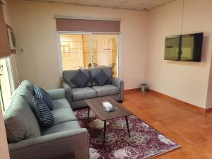 a living room with a couch and a table at La Fontain Resort Al Shafa in Al Shafa