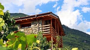 a log cabin in the mountains with a sky at Una casa tra gli alberi in Tresivio