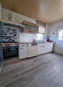 eine Küche mit weißen Geräten und einer Holzdecke in der Unterkunft MAISON COSY 7 minutes des frontières in Rosenau