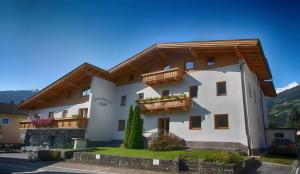 un gran edificio blanco con balcones. en Ferienwohnungen Hell, en Uderns