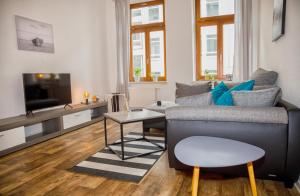 uma sala de estar com um sofá e uma mesa em Blue Chili 20 - Zentral in der CITY WLAN bis 4 Pers em Magdeburg