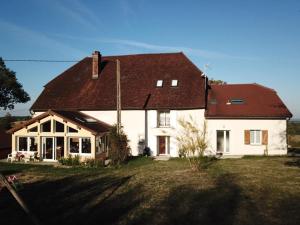 a large white house with a brown roof at La Ferme De Montard in Montmorot
