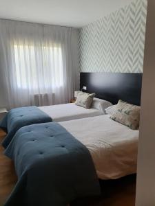 オ・ペドロウソにあるNoja rooms 1のベッドルーム1室(青いカバーのベッド2台付) +13枚の写真