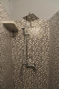 eine Dusche in einem schwarz-weiß gefliesten Bad in der Unterkunft B&B Piazza Municipio in San Vito