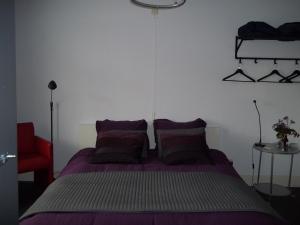 a bedroom with a purple bed and a red chair at &quot;t Griene Hemeltsje in Wijckel