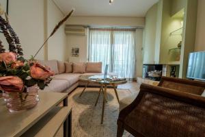 een woonkamer met een bank en een tafel bij Karamba boutique living - ECO Riverside Appartment in Volos
