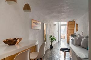 a living room with a couch and a table and chairs at Akron Cliff Suite in Fira +37 photos