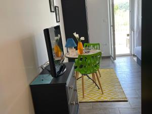 a living room with a tv and a table with a green chair at Casa Fumica Studio in Kampor
