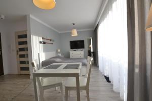 a bedroom with a bed and a table and chairs at Darłówko Apartament Morski in Darłówko