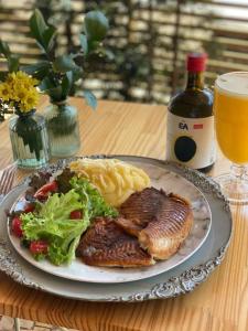 um prato de comida com carne e massa e uma garrafa de vinho em Hotel Parati Minas em Uberlândia