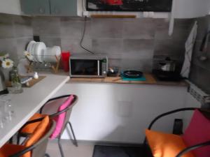 een keuken met een aanrecht met stoelen en een magnetron bij APARTAMENT POD DZIEWIĄTKĄ in Sandomierz