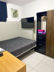 Habitación pequeña con cama y TV de pantalla plana. en Apartamento Independiente 1 dormitorio cama Queen, en Lima