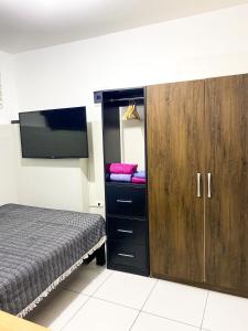Apartamento Independiente 1 dormitorio cama Queen في ليما: غرفة نوم مع سرير وكابينة مع مرآة
