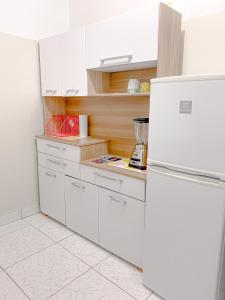  La cuisine est équipée de placards blancs et d'un réfrigérateur. dans l'établissement Apartamento Independiente 1 dormitorio cama Queen, à Lima