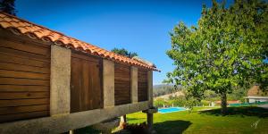 un edificio in legno con un albero e una piscina di ESPECTACULAR CASONA DO CEREIXO NO VAl MIÑOR a Pontevedra