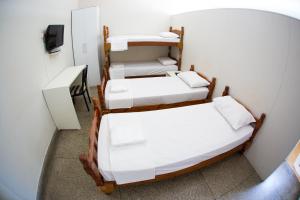 eine Gruppe von 4 Betten in einem Zimmer in der Unterkunft Apartamento ou Flat no Centro in Campinas
