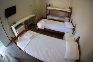 カンピーナスにあるApartamento ou Flat no Centroのベッドが2つとテレビがある部屋