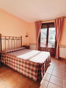 - une chambre avec un lit et une couverture en damier dans l'établissement Hotel Valdevécar, à Albarracín