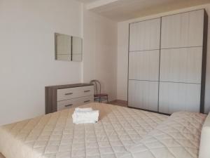 a bedroom with a large bed and a dresser at Lido Venere Case Vacanze in Metaponto