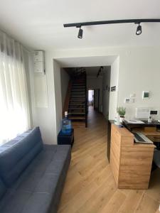 ein Wohnzimmer mit einem blauen Sofa und einer Treppe in der Unterkunft Villa SOFI in Lwiw
