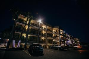un bâtiment avec des voitures garées dans un parking la nuit dans l'établissement Hotel Calafia, à Mexicali